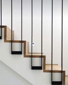 the stairs are made of wood and metal with black bars on each handrails