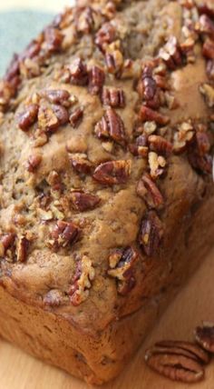 a loaf of pecan bread sitting on top of a wooden cutting board