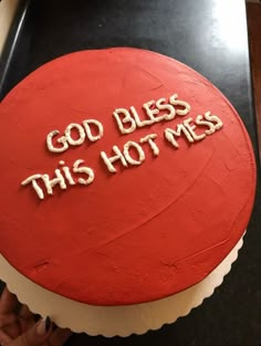 a red cake with white frosting that says, god bless this hot mess on it