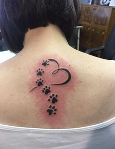 the back of a woman's shoulder with paw prints on it and a heart in the middle