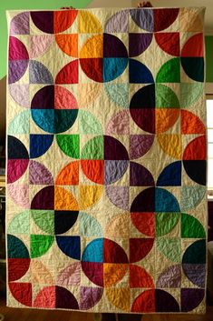 a multicolored quilt hanging from the ceiling