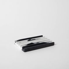 three pieces of black and white marble sitting on top of each other in front of a white background