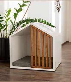 a dog house with a plant in it and a cat bed on the floor next to it