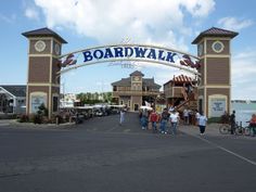 people are walking under the entrance to boardwalk