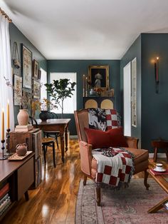 a living room filled with furniture and pictures on the wall above it's windows