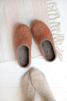 a pair of slippers sitting on top of a white floor next to a rug