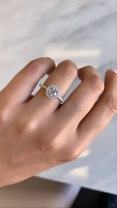 a woman's hand with a diamond ring on it