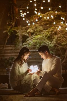 two people sitting on the ground with lights in the background and text that reads spazio