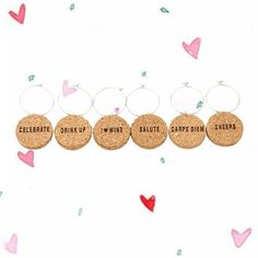 four wine cork earrings with the words celebrate, drink up, and smile on them