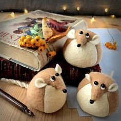 three stuffed animals sitting on top of an open book