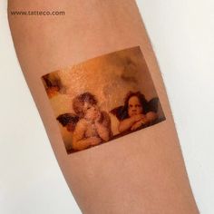 an image of two cherubs on the arm