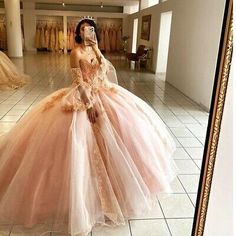 a woman in a pink dress is taking a selfie with her cell phone while wearing a tiara