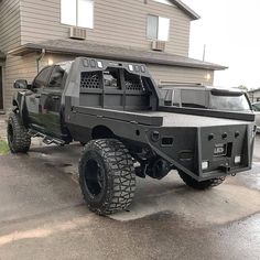 a large black truck parked in front of a house