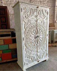 an old white cabinet with carvings on it