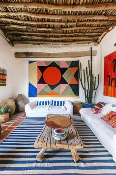 a living room with couches, rugs and paintings hanging on the wall above them