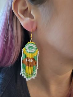 a close up of a person wearing some kind of beaded earring that has a cartoon character on it