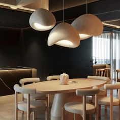 a dining room table with chairs and lights hanging from the ceiling