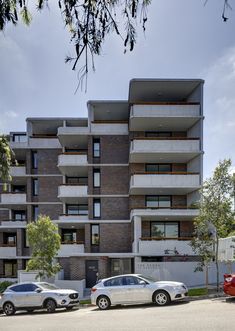 two cars parked in front of an apartment building