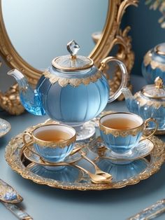 a blue tea set sitting on top of a table next to a gold trimmed mirror