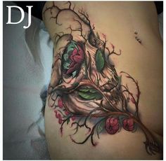 a woman's stomach with flowers and leaves tattooed on the side of her body