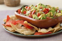 a plate filled with tortilla chips and guacamole on top of it