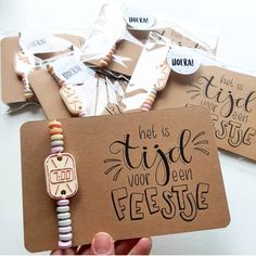 a person holding up a brown card with some words on it and beaded bracelets