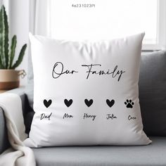 a white pillow with the words our family printed on it and four hearts in black ink