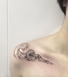 a woman's chest with a wave tattoo on it