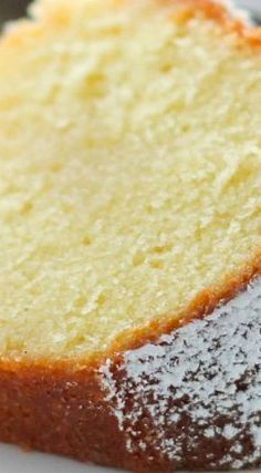 a close up of a piece of cake on a plate with powdered sugar sprinkled on top