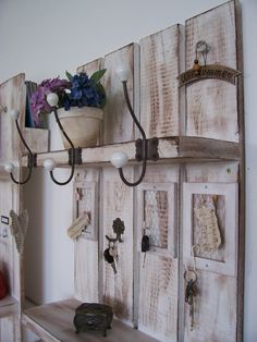 an old wooden shelf with many keys and flowers on it, hanging from the wall