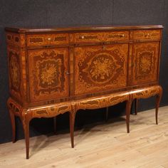 an ornately decorated wooden sideboard on display