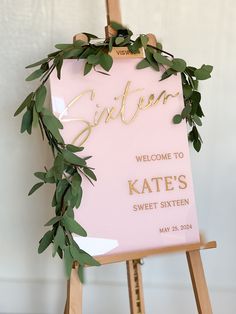 a pink sign with greenery on it that says welcome to kate's sweet sixteen