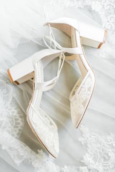 a pair of white shoes with lace on them