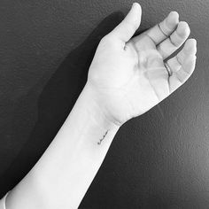 a person's arm with a small tattoo on it