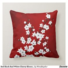 a red pillow with white and black flowers on the front is featured in this image