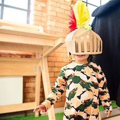 a young child wearing a bird cage hat