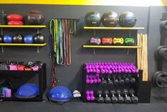 there are many different types of gym equipment in this room, including dumbbells and exercise balls