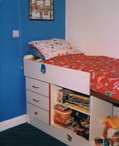 a bedroom with blue walls and white drawers