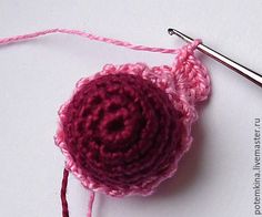 a crocheted ball of yarn sitting on top of a table next to a knitting needle