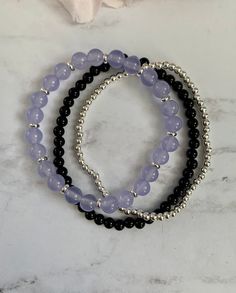 "Gorgeous bracelet stack made of three beaded bracelets: 1. 6mm purple amethyst quartzite beads with silver spacers 2. 4mm black onyx beads 3. 3mm sterling silver beads These are perfect to wear alone, all together or add to a bracelet stack. The bracelets shown are approximately 7\" in length." Black Amethyst 8mm Bead Bracelets, Black Amethyst Bracelets With 8mm Beads, Black Amethyst Bracelet With 8mm Beads, Black Beaded Amethyst Jewelry, Black Amethyst Beaded Bracelets, Black Amethyst Gemstone Beaded Bracelets, Silver Onyx Beaded Bracelets With 8mm Beads, Adjustable Black Amethyst Beaded Bracelets, Silver Onyx Beaded Bracelet With Black Beads