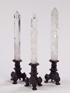 three crystal candlesticks sitting next to each other on top of a white surface