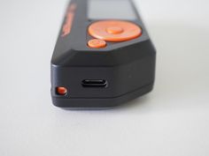 an orange and black cell phone sitting on top of a white table