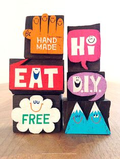 four wooden blocks that say hand made, eat diy, free and have faces on them