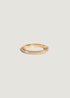 a yellow gold band with three baguettes on the side, set in white diamonds