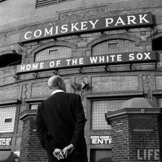 a man standing in front of a building with the words comisky park on it