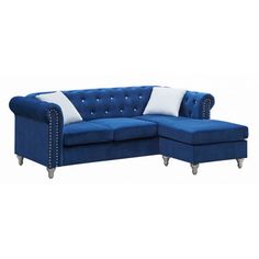 a blue sectional couch with white pillows on it