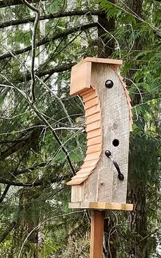 a bird house made out of wood in the woods