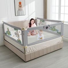 a woman sitting in a baby crib next to a window with pictures on it