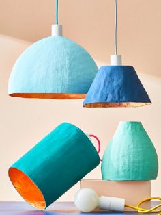 three different colored lamps hanging from the ceiling