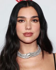 a woman with long black hair wearing a choker necklace and diamond jewelry on her neck